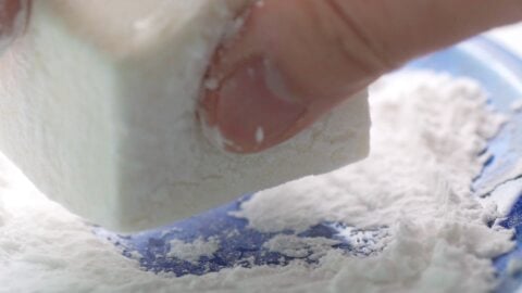 Coating tofu in potato starch to make agedashi tofu.