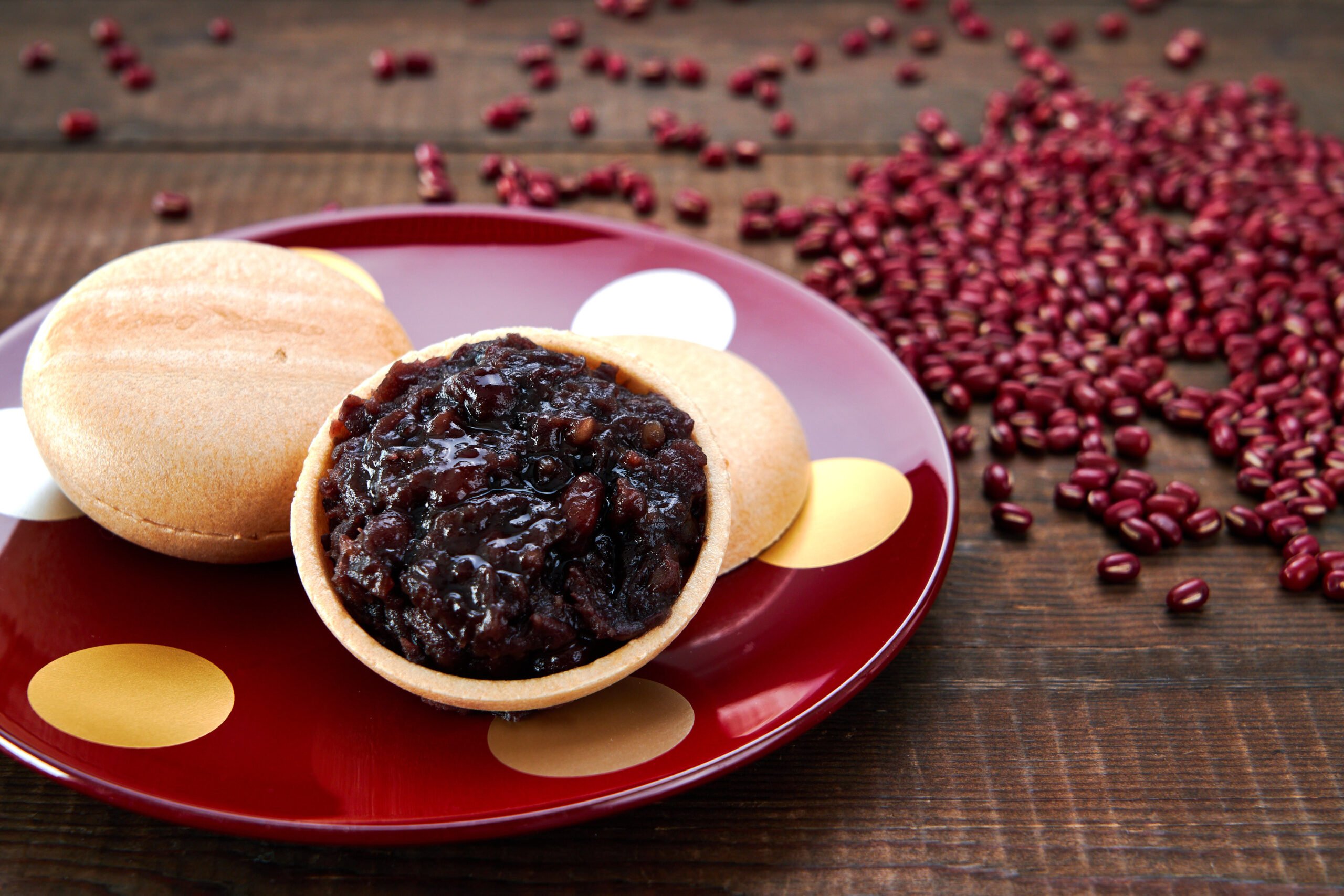 Anko, or Japanese red bean paste stuffed into monaka with adzuki beans in the background.