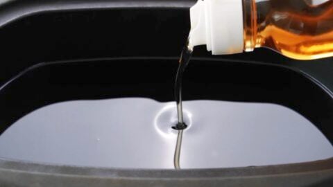 Pouring sesame oil into a pot for deep frying the tofu.