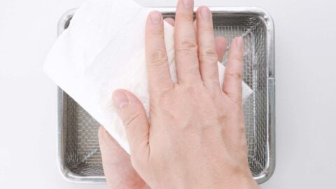 Drying off tofu with paper towels.