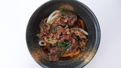 Beef udon noodle soup in a serving bowl.