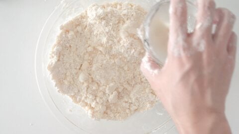 Making a flaky all-butter pie dough. Mixing in ice water.