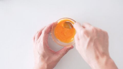 Mixing egg yolk wash for the top crust of apple pie.