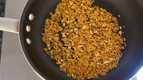 Toast breadcrumbs in a pan to make a cheesy crispy topping for the mac and cheese.