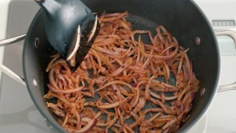 Guanciale, red onions, and chili flakes in a pan.