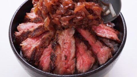 Rice bowl topped with sliced Chaliapin Steak and onion sauce.