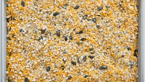 Cheese and savory granola mixture spread out on a baking sheet.