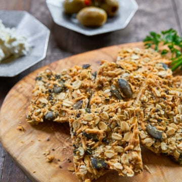 Cheesy and delicious savory granola bars are loaded with cheddar, parmesan, oats, pumpkin seeds, sesame seeds, and chia seeds and baked until crisp.