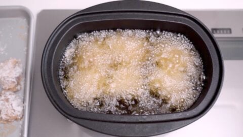 Karaage frying in oil in a cast iron pot.