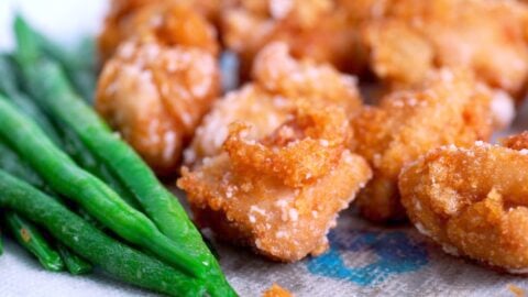 Fried chicken Karaage with green beans draining on paper towels.