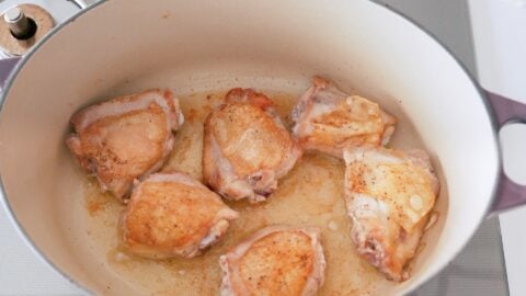 Chicken browned on the skin-side in a Dutch Oven.