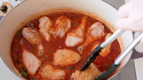 Chicken being simmered in a paprika sauce.