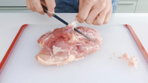 Trimming chicken leg.