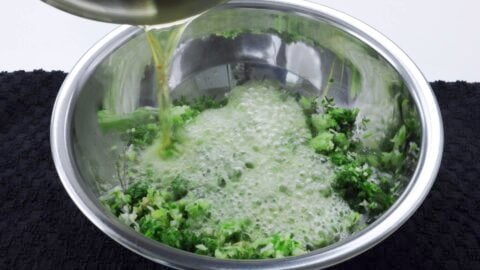 Pouring hot oil over ginger and scallions.