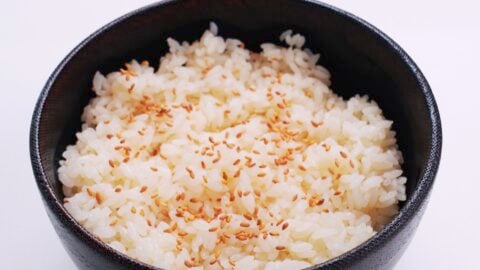 Bowls of sushi rice topped with toasted sesame seeds.