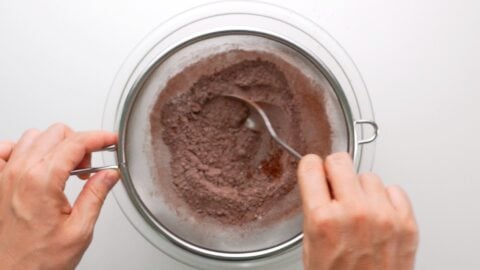 Sifting flour, cocoa powder, salt, and baking powder together for making brownies.