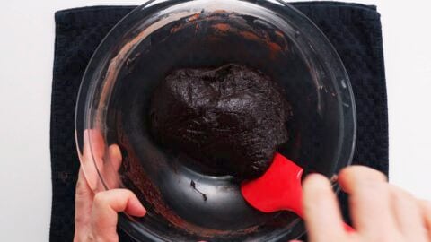 Chocolate mochi being kneaded with a red spatula.