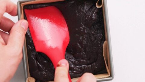 Chocolate mochi being pressed into a square mold.