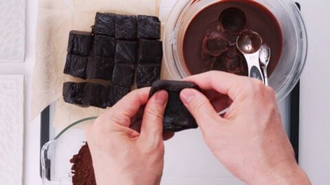 Flattening out chocolate mochi with fingers.