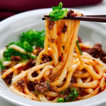 Cold udon noodles in a creamy sesame broth topped with spicy chili oil and beef.