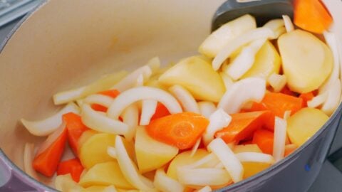 Sauteeing onions, carrots and potatoes for cream stew.