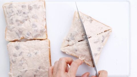 Cutting shrimp toast into triangles.