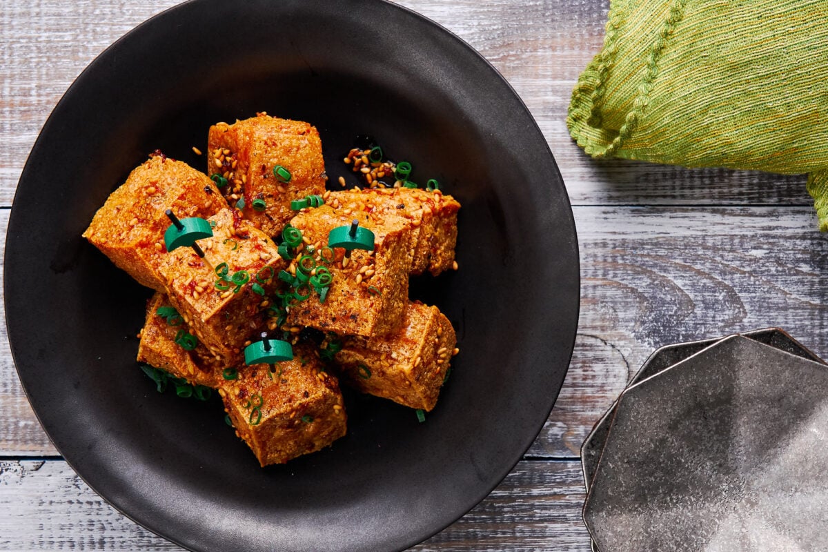 Crispy tofu bites glazed in a ginger garlic sauce and topped with toasted sesame seeds, black pepper and scallions.