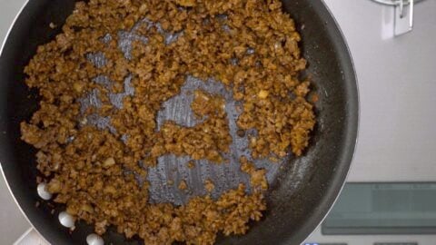 Curry flavored ground beef cooking in a frying pan.