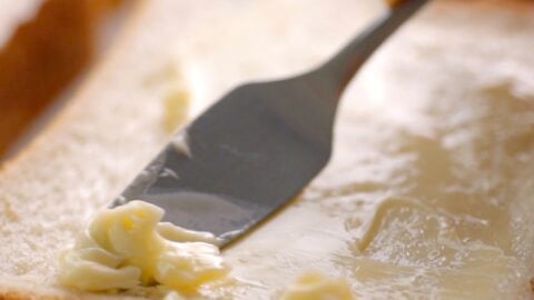 Spreading butter on sandwich bread.