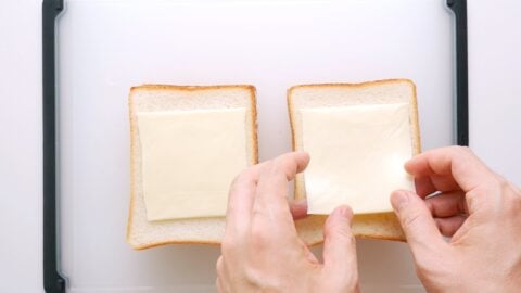 Adding a slice of American Cheese to sandwich bread for Curry Bread.