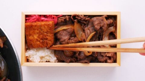 Adding benishōga and braised tofu to Rengoku's bento.