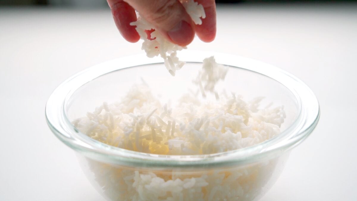 Crumbling leftover rice into a glass bowl.