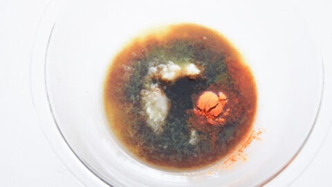 Tocino marinade in a glass bowl on a white counter.