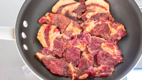 Tocino frying in a pan.