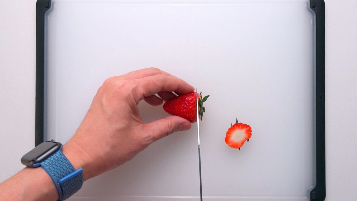 Removing the tops from strawberries.