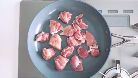 Pan-frying chicken for making ginger chicken.