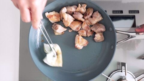 Wiping the fat out of a pan with paper towels.