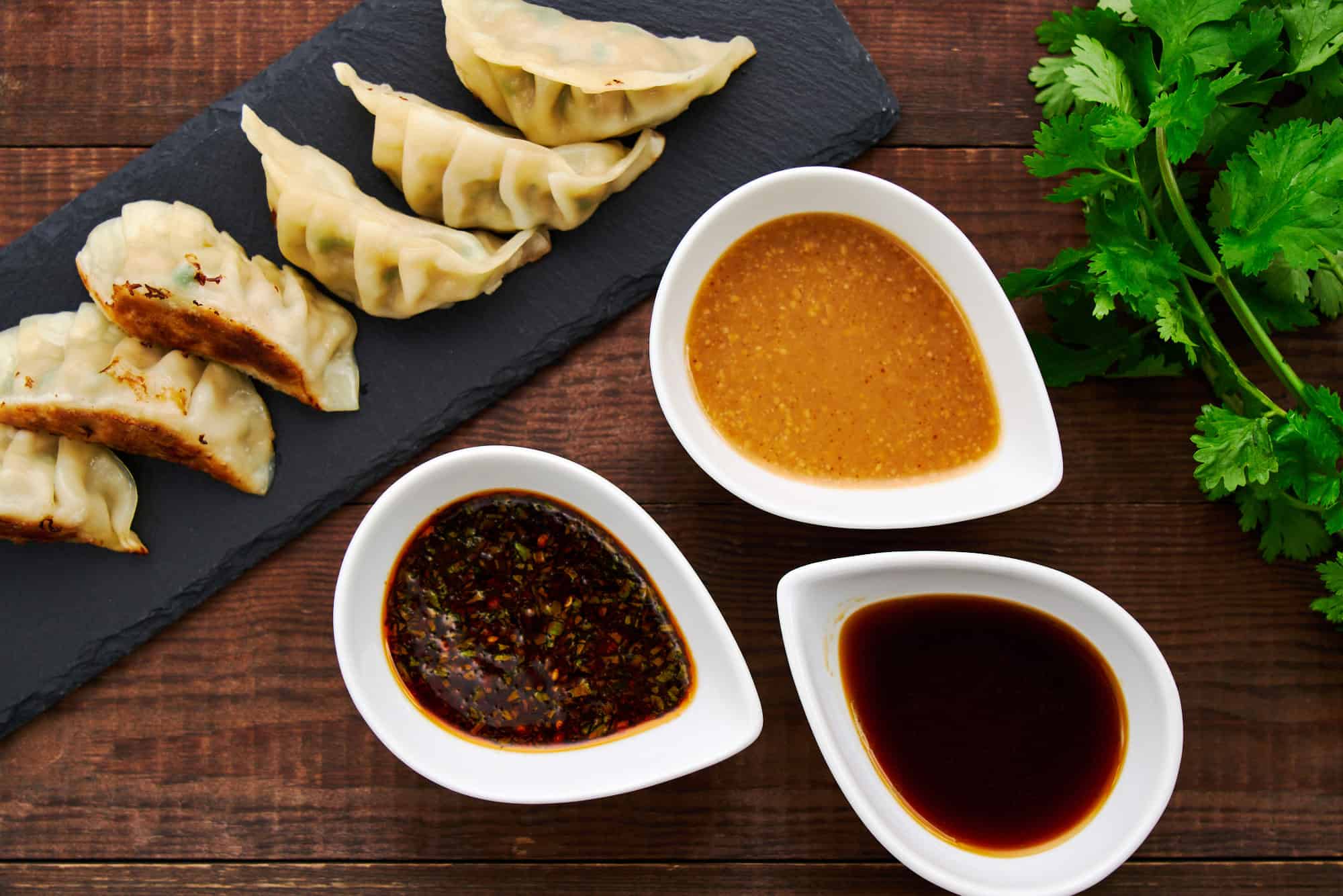 Vibrant and flavorful, these three gyoza sauces form a mouthwatering backdrop to a steaming platter of perfectly golden-brown Japanese potstickers.