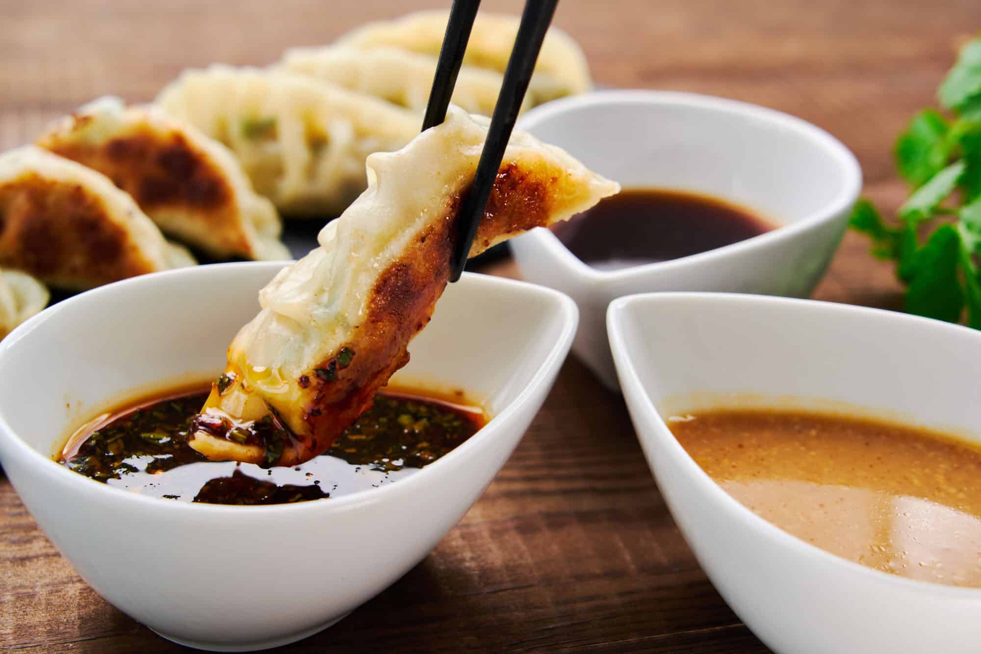 Dipping a Japanese gyoza dumpling in a spicy gyoza dipping sauce.