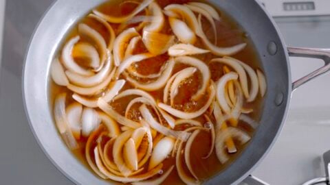 Simmering onions together with a dashi broth to make gyudon.