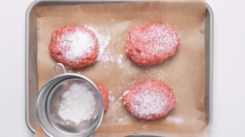 Dusting Hamburg Steak patties with potato starch.