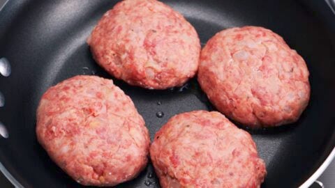 Raw hamburg steaks in a frying pan.