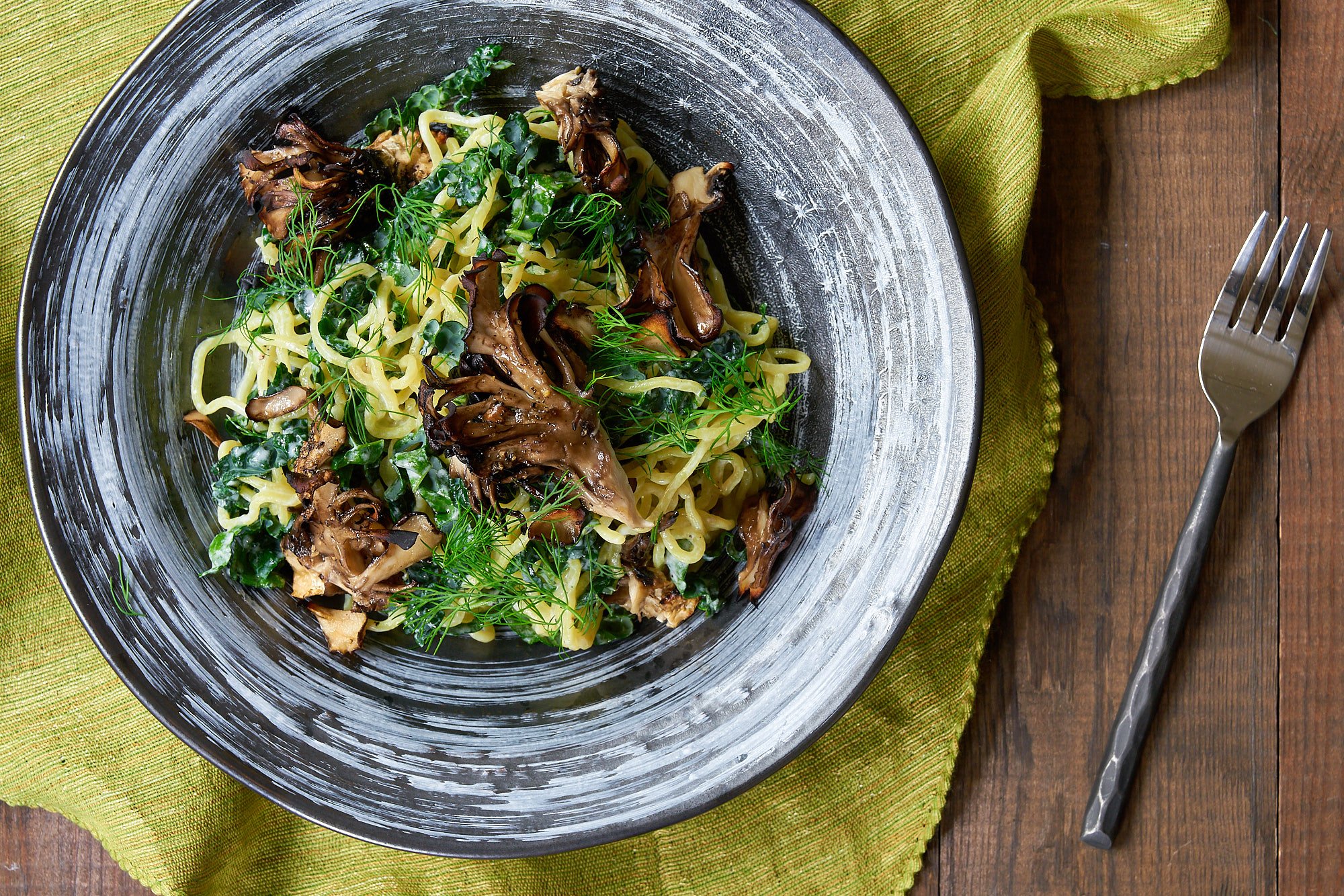 This ramen salad is tossed with lacinato kale and dill, with a creamy lemon garlic sauce and crispy roasted maitake mushrooms.