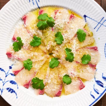 Kanpaccio (Kanpachi Carpaccio) is a delightfully simple appetizer with paperthin slices of Kanpachi (Greater Amberjack) seasoned with olive oil, cheese and lime zest.