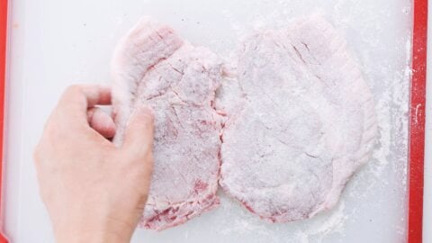 Pork cutlets dusted with flour for making katsu.