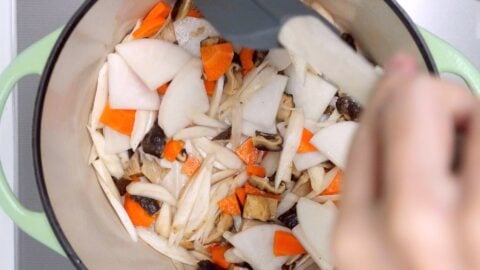 Stir-frying daikon, carrots, burdock, and shiitake mushrooms.