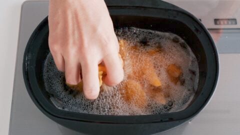 Making the French fry topping for Lomo Saltado by deep-frying potatoes in oil.