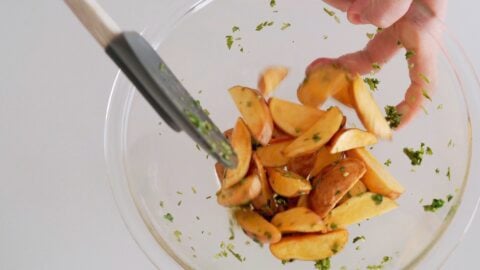 Tossing fried potatoes in vinegar and salt to make the topping for Lomo Saltado.