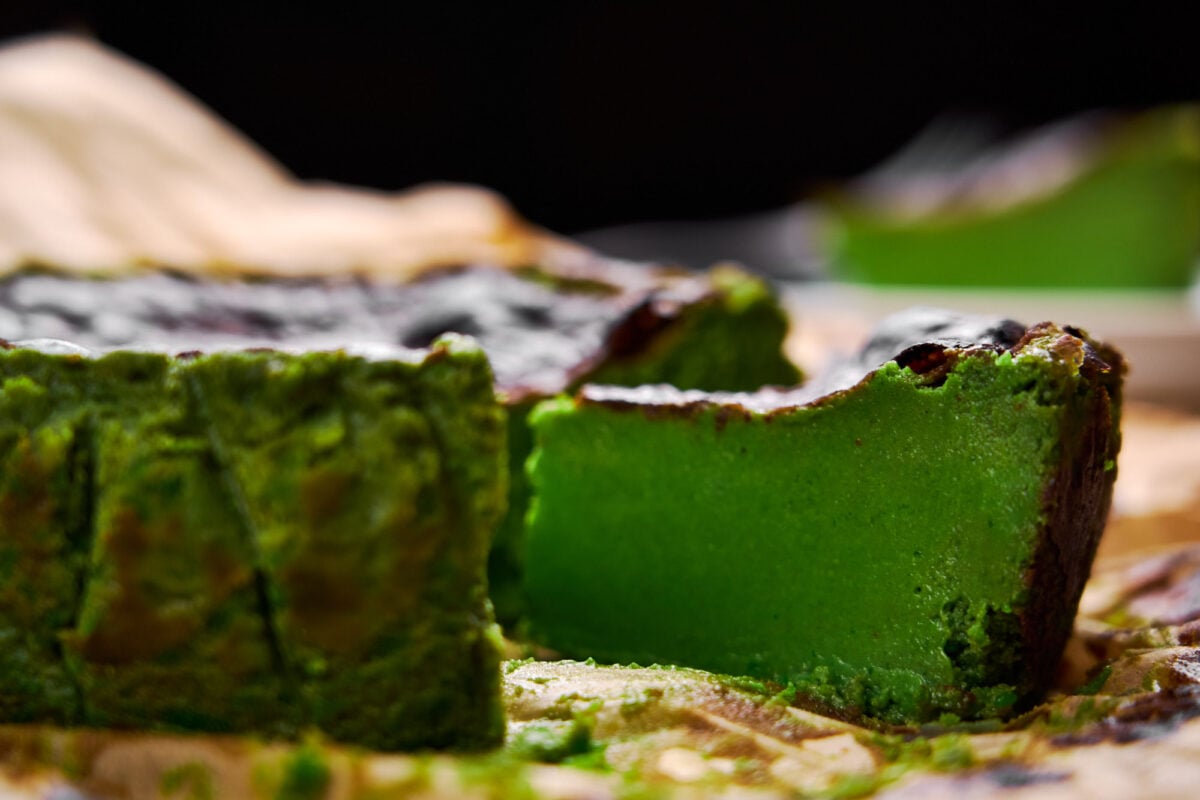 A slice of Matcha Basque Cheesecake with a custardy smooth green tea center and caramelized top.