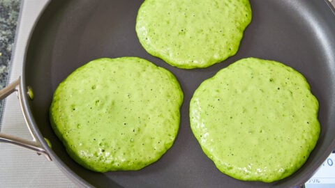 Green matcha panckaes in a pan.